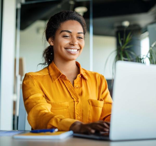 Women in orange shirt using laptop